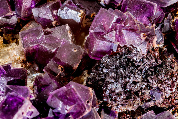 alt: Fluorit je minerál mnoha barev. Může být čirý, žlutý, zelený, růžový i fialový. Jeho krystaly mají často tvar krychlí. Vzorek na snímku pochází ze sbírky Mineralogického muzea Přírodovědecké fakulty UK. Foto Petr Jan Juračka.