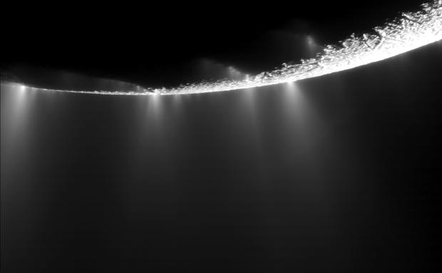 alt: Gejzíry tryskající blízko jižního pólu Enceladu, jak je vyfotografovala sonda Cassini v roce 2009. Zdroj Wikimedia Commons, kredit NASA/JPL/SSI, volné dílo / Public Domain.