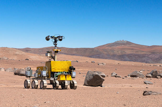 alt: Ilustrační obrázek: Prototyp robotického vozítka pro misi ExoMars 2020. Snímek pochází z testování v chilské poušti Atacama. Zdroj Wikimedia Commons, autor ESO / G. Hudepohl, úpravy Jan Kolář, licence CC BY 4.0.