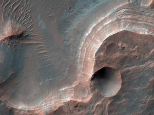 alt: Světle zbarvené vrstvy v kráteru Cross, Terra Sirenum, pravděpodobně obsahují alunit, kaolinit a dalšími hliníkem bohaté sloučeniny. Zdroj NASA/JPL-Caltech/UArizona