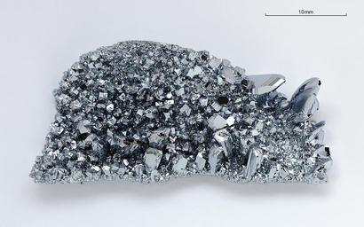 alt: Krystaly osmia. Osmium je prvek s nejvyšší známou hustotou – 22,59 gramu na centimetr krychlový. Zdroj Wikimedia Commons, autor Alchemist-hp, licence CC BY-NC-ND 3.0.