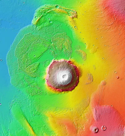 alt: Olympus Mons a jeho širší okolí. Výška útvarů je vyznačena barevnou škálou (modrá – nejnižší, bílá – nejvyšší). Zdroj Wikimedia Commons, kredit NASA / JPL-Caltech / Arizona State University, volné dílo / Public Domain.