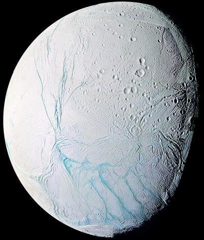 alt: Obrázek Enceladu v umělých barvách, který vznikl složením snímků pořízených v ultrafialové, viditelné a infračervené oblasti spektra. Výrazným modrým liniím v dolní části obrázku se přezdívá tygří pruhy. Zdroj Wikimedia Commons, kredit NASA / JPL / Space Science Institute, volné dílo / Public Domain.