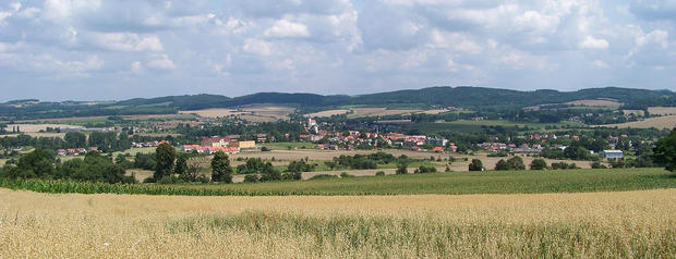 alt: Pohled na Sedlec-Prčici a okolní kopcovitou krajinu. Zdroj Wikimedia Commons, autor ŠJů, licence CC BY-SA 3.0.