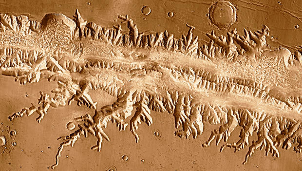 alt: Planiny, krátery, kaňony, a dokonce i sesuvy hornin – fotografie z nejnovějších sond zkoumajících Mars jsou obdivuhodně detailní. Vědci z nich dokážou zjistit mnoho informací o geologickém vývoji rudé planety. Tento snímek oblasti Ius Chasma pořídila sonda 2001 Mars Odyssey. Zdroj Wikimedia Commons, kredit NASA / JPL-Caltech / University of Arizona, volné dílo / Public Domain.