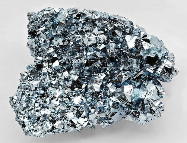 alt: Osmium je tvrdý, křehký, stříbrošedý kov s modravým nádechem. Na snímku jsou uměle připravené krystaly čistého osmia. Zdroj Wikimedia Commons, autor Alchemist-hp, úpravy Jan Kolář, licence Free Art License 1.3.